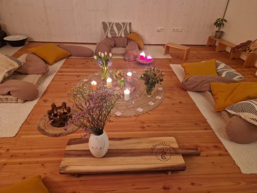Ritualgestaltung im WunderRaum. Mit Blumen, Kerzen und vielen Kissen.